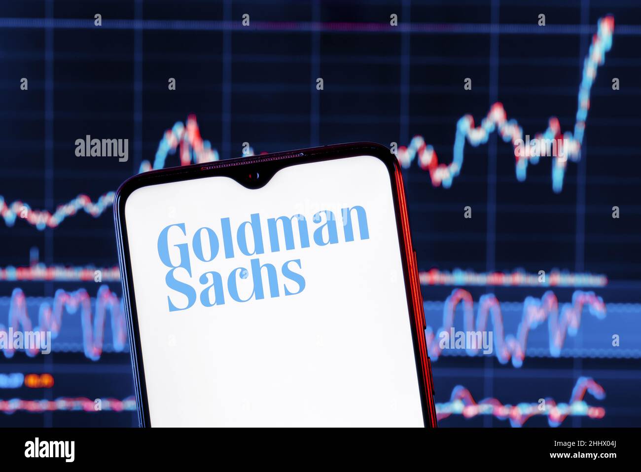 Smartphone with Goldman Sachs bank logo. Goldman Sachs stock chart on the background. Stock Photo