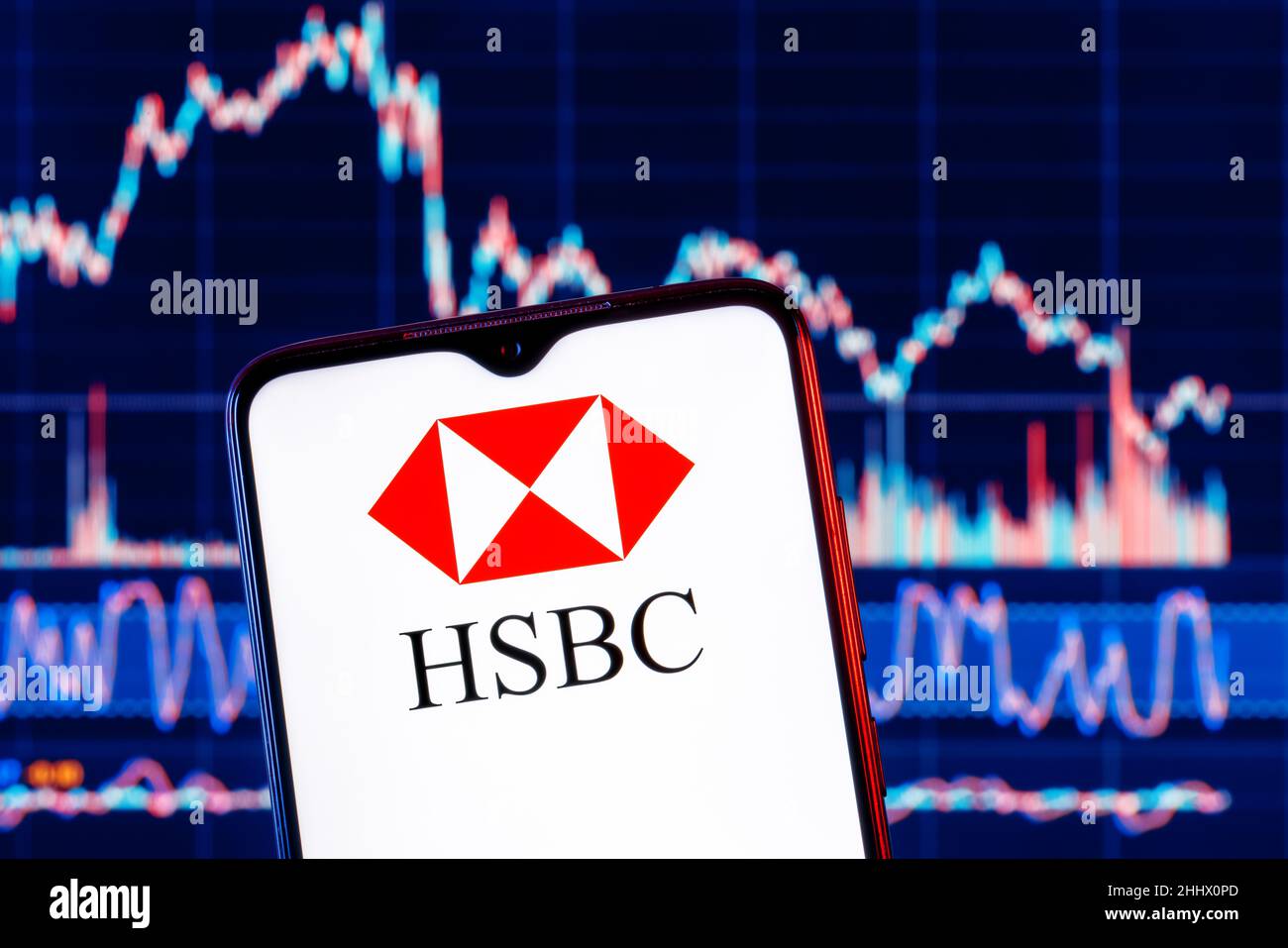 Smartphone with HSBC bank logo. HSBC stock chart on the background. Stock Photo