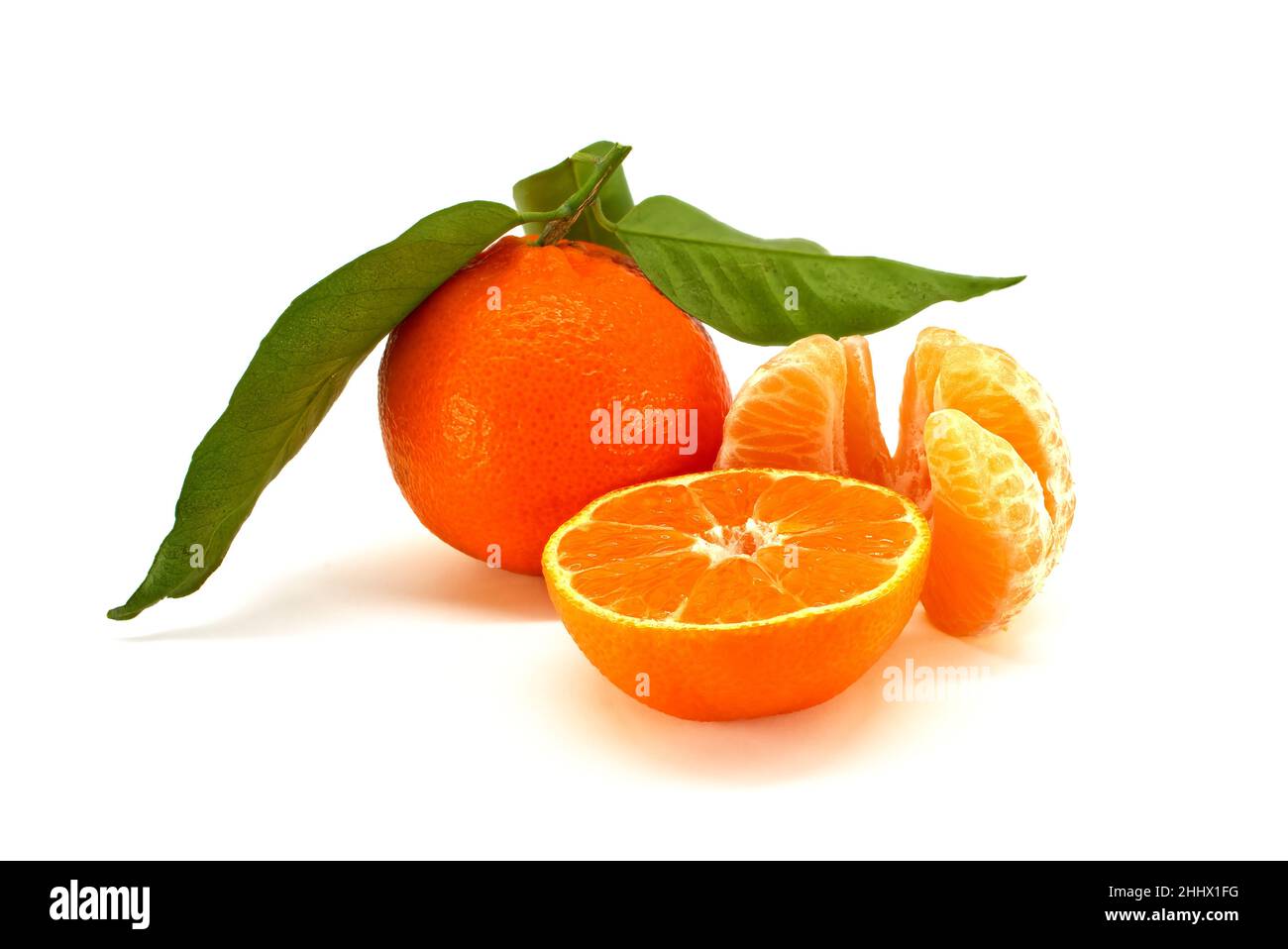 Mandarin orange, tangerine or clementine fruit with green leaves, half