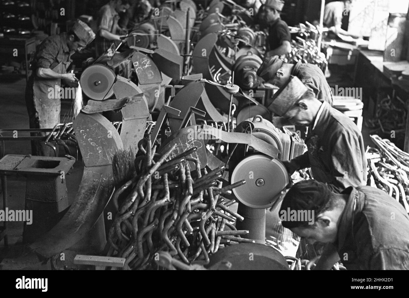 Workers on the production line at the Bianchi motorcycle factory in Milan producing handle bars . Circa 1955 Stock Photo