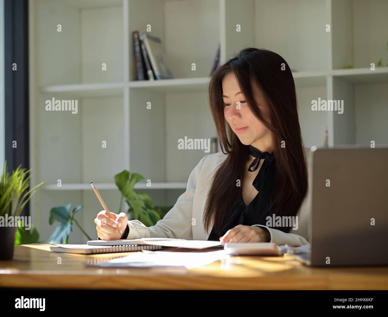 Beautiful Asian young college student doing her financial homework ...