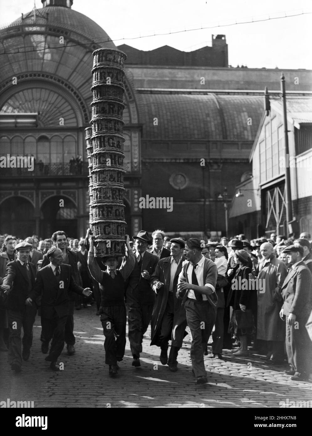 Porters from Covent Garden Flower and Vegetable market race with baskets stacked on their head as part of the Covent Garden Flower Show 12th June 1951 Stock Photo