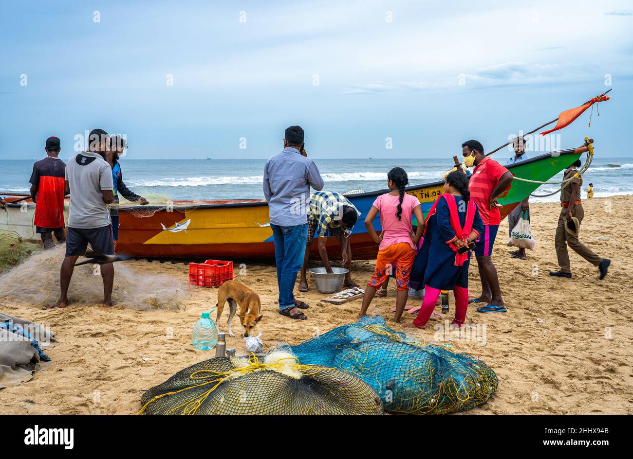 A group of unknown people buying fresh fish from a street vendor on Edward Elliot's Beach. Stock Photo