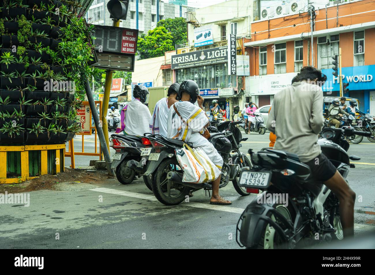 A group of unknown adult males wearing helmets at the traffic signal in Adyar Stock Photo