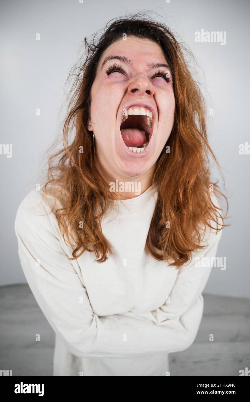 Close-up portrait of insane woman in straitjacket on white background. Stock Photo