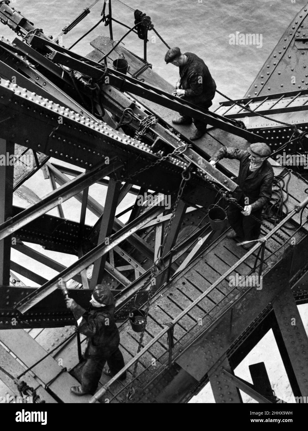 The men of the bridge. Painting the Forth Bridge is a long and complex task, taking three years to complete. It requires 50 tons of paint each year and a squad of 24 men working permanently.  Each painter must have a complete disregard for height and the agility of a cat. Working 300 feet above the Forth calls for no ordinary tradesmen. The lower girders of the structure, lashed continually by salt spray, are painted with a black mixture, mainly composed of pitch. This was the idea of Foreman Paton and it counteracts the quick corrosive actions of the salt.  12th September 1949. Stock Photo