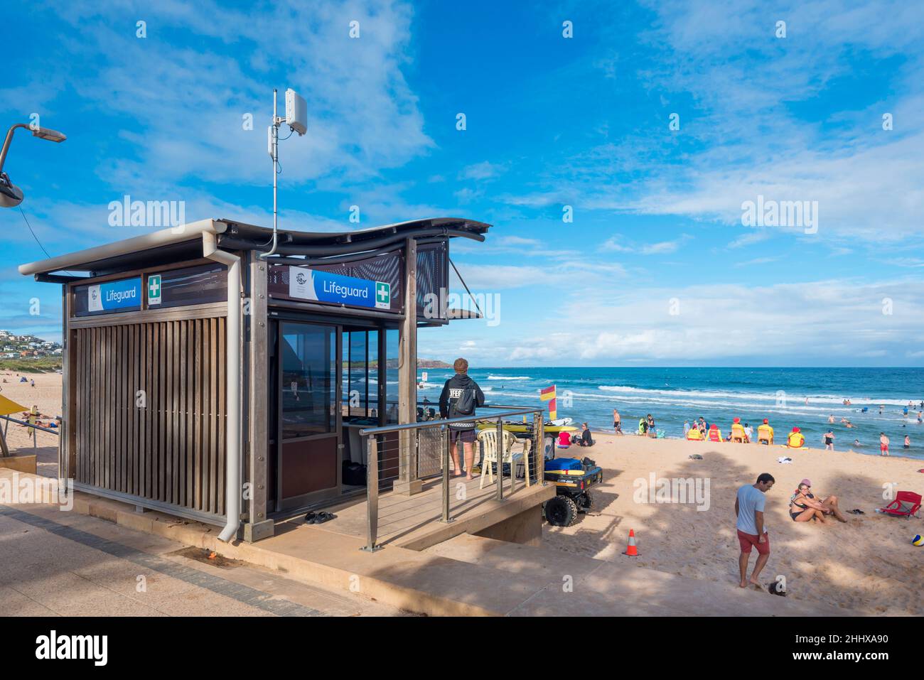 The Lifeguard station and on the beach in yellow, volunteer Lifesavers, at Dee Why Beach in Sydney, New South Wales, Australia Stock Photo