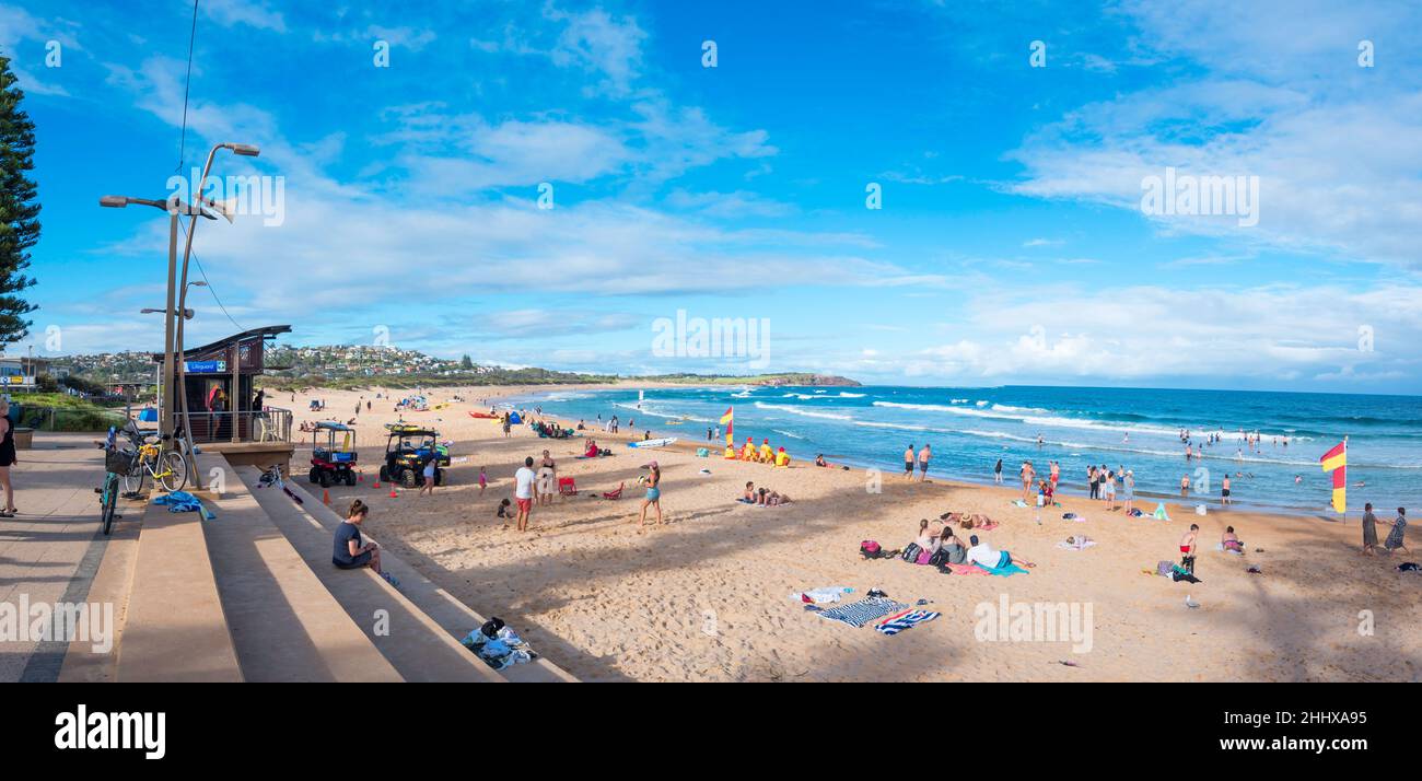 A panoramic image of the Lifeguard station and on the beach in yellow, volunteer Lifesavers, at Dee Why Beach in Sydney, New South Wales, Australia Stock Photo