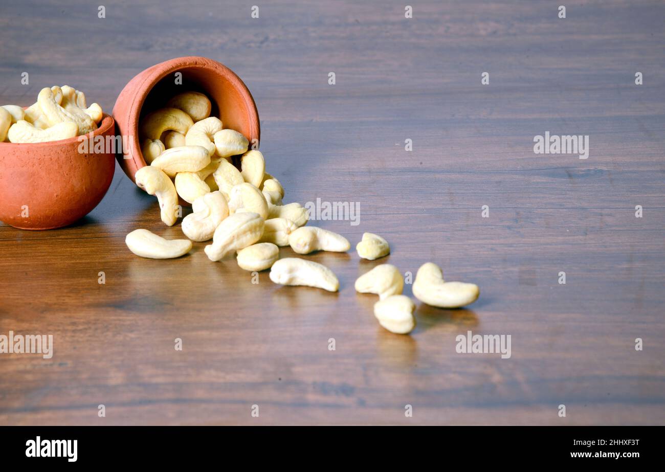 Roasted salted raw cashew nuts in a wooden bowl on a rustic table