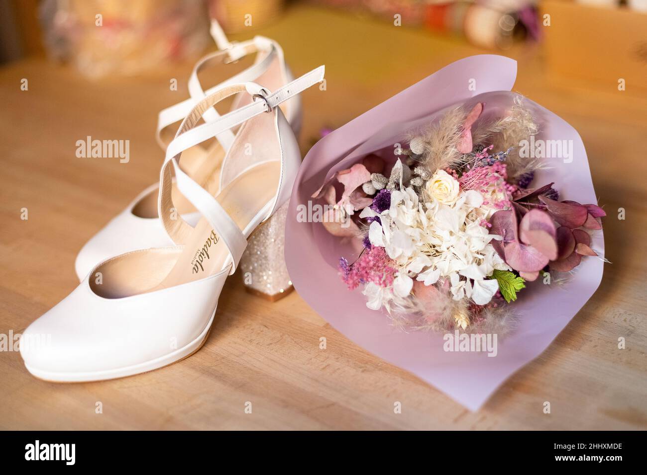 The bridal shoes with a wedding bouquet on the floor Stock Photo