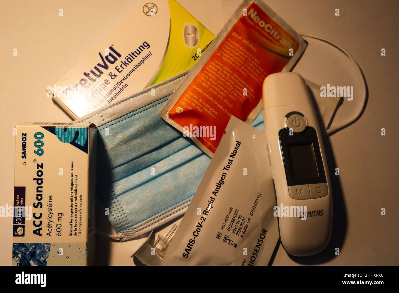 Berne, Switzerland, 05. January 2022: Medical Mask, Clinical Thermometer and Fever, Flu and Cold Medications. Stock Photo