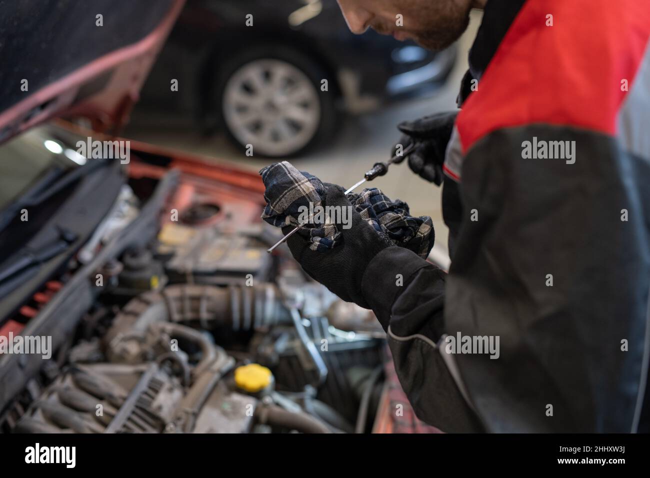 Gloved mechanic in workwear preparing handtool for repairing car while