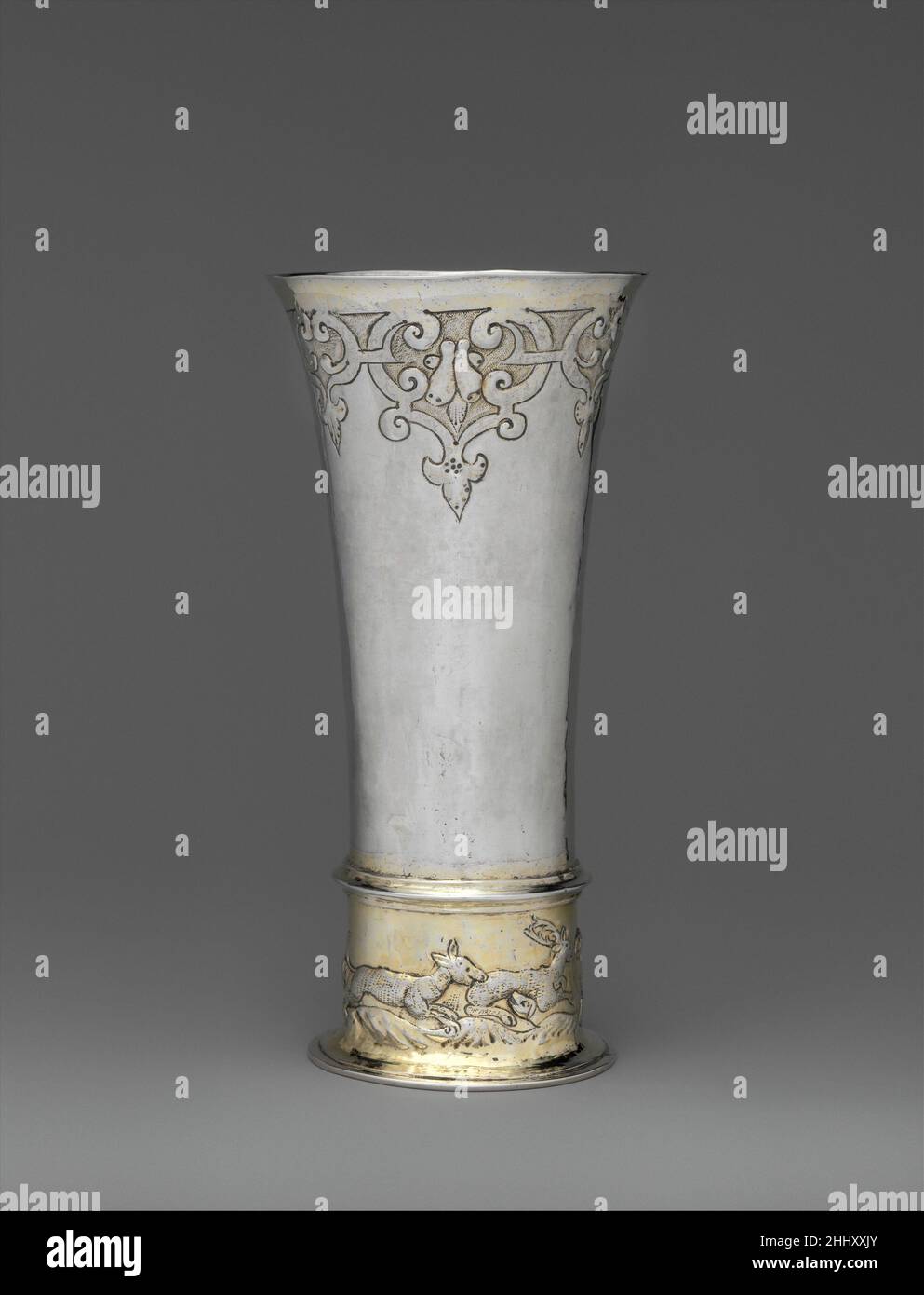 Footed beaker mid-17th century Possibly by Thomas Trepches II The proximity of Hungary to the Ottoman Empire may explain why Hungarian craftsmen and patrons often favored Oriental-inspired patterns, like the stylized arabesque scrollwork below the lip on this beaker, which had been out of fashion in Western Europe for almost two generations. The hunting scene at the base refers to the exclusive right of the local nobility to hunt certain game animals.LiteratureTihamér Gyárfás. A brassai ötvösség története. Brassó, 1912, p. 107, no. 179.Judit H. Kolba. Hungarian Silver: The Nicolas M. Salgo Col Stock Photo
