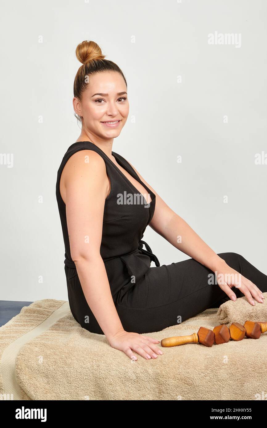 A pretty professional Caucasian masseuse with a lot of wooden tools of a cellulite massage Stock Photo