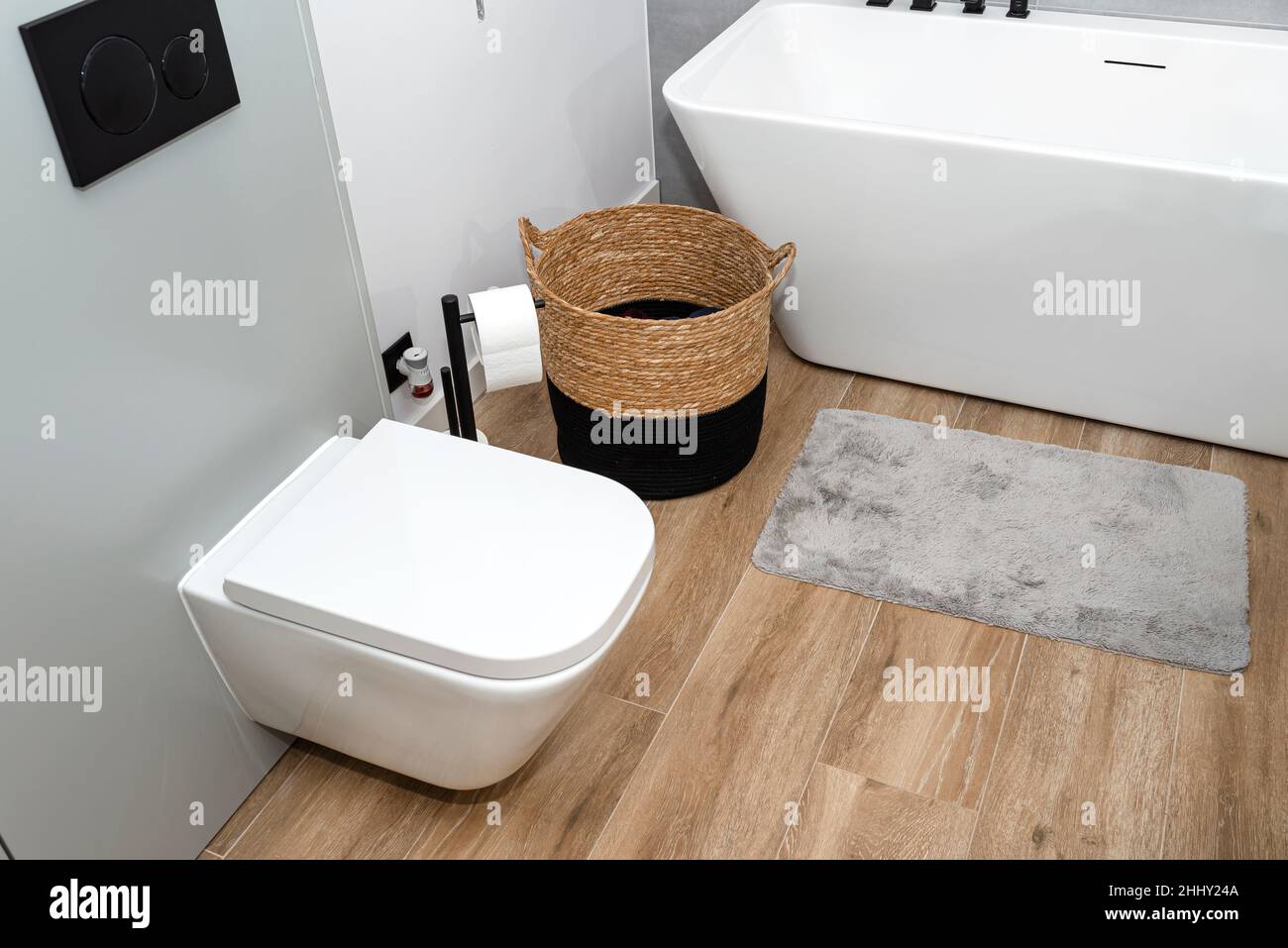 A wicker laundry basket with dirty clothes in the bathroom next to the