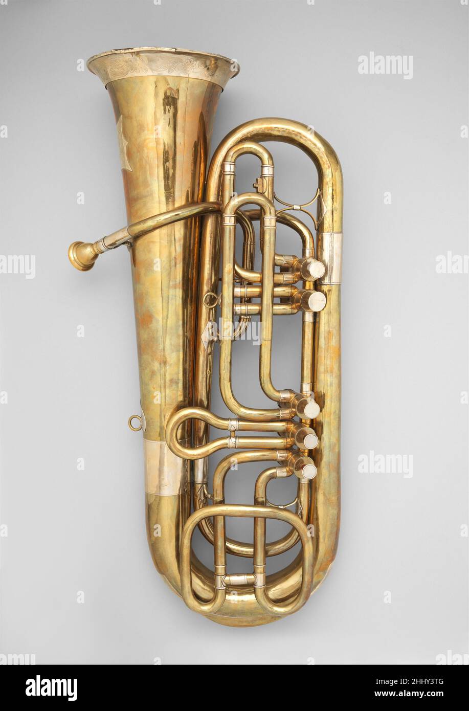 Tuba ca. 1855 attr. C.W. Moritz The overall design of the instrument and configuration of its valves is similar to the early tubas made by Johann Gottfried Moritz in Berlin. It has five Berlin valves (bottom-sprung with a single guide slot) and each valve loop has a tuning slide. The bell garland is engraved with a flower, oak leaf and acorn motif. The white metal plaque affixed to the bell bears no maker’s description but is decorated in the same style as the bell garland. The motif and the style of execution is typical of instruments made in Markneukirchen during the mid-nineteenth century.. Stock Photo
