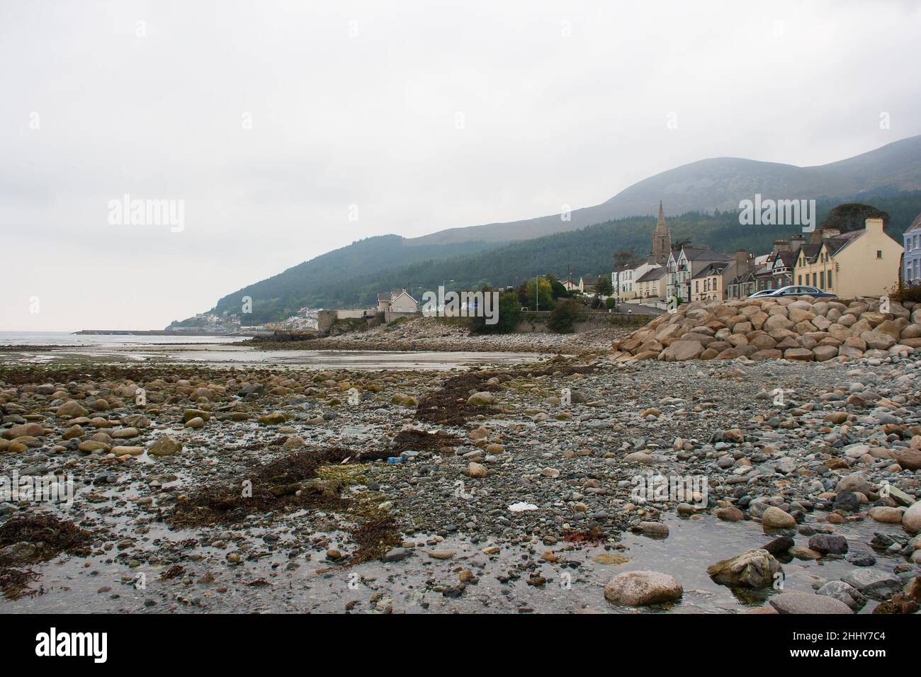 A view of the Mountains of Mourne  and Tollymore Forest Park from the stony breakwater on the beach at Newcastle County Down in Northern Ireland Stock Photo