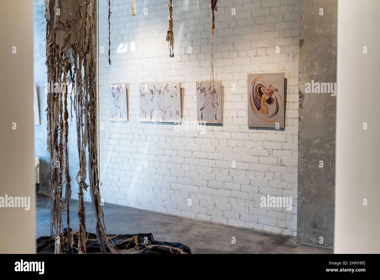 Image of modern studio with beautiful painted pictures hanging on brick wall Stock Photo