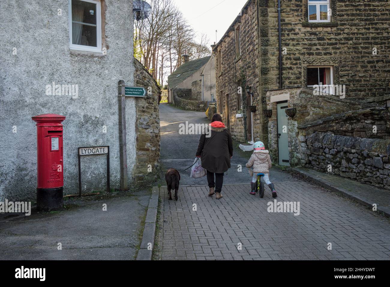 Local people walking a dog at Lydgate in Eyam, the 'plague village', Peak District National Park, Derbyshire Stock Photo