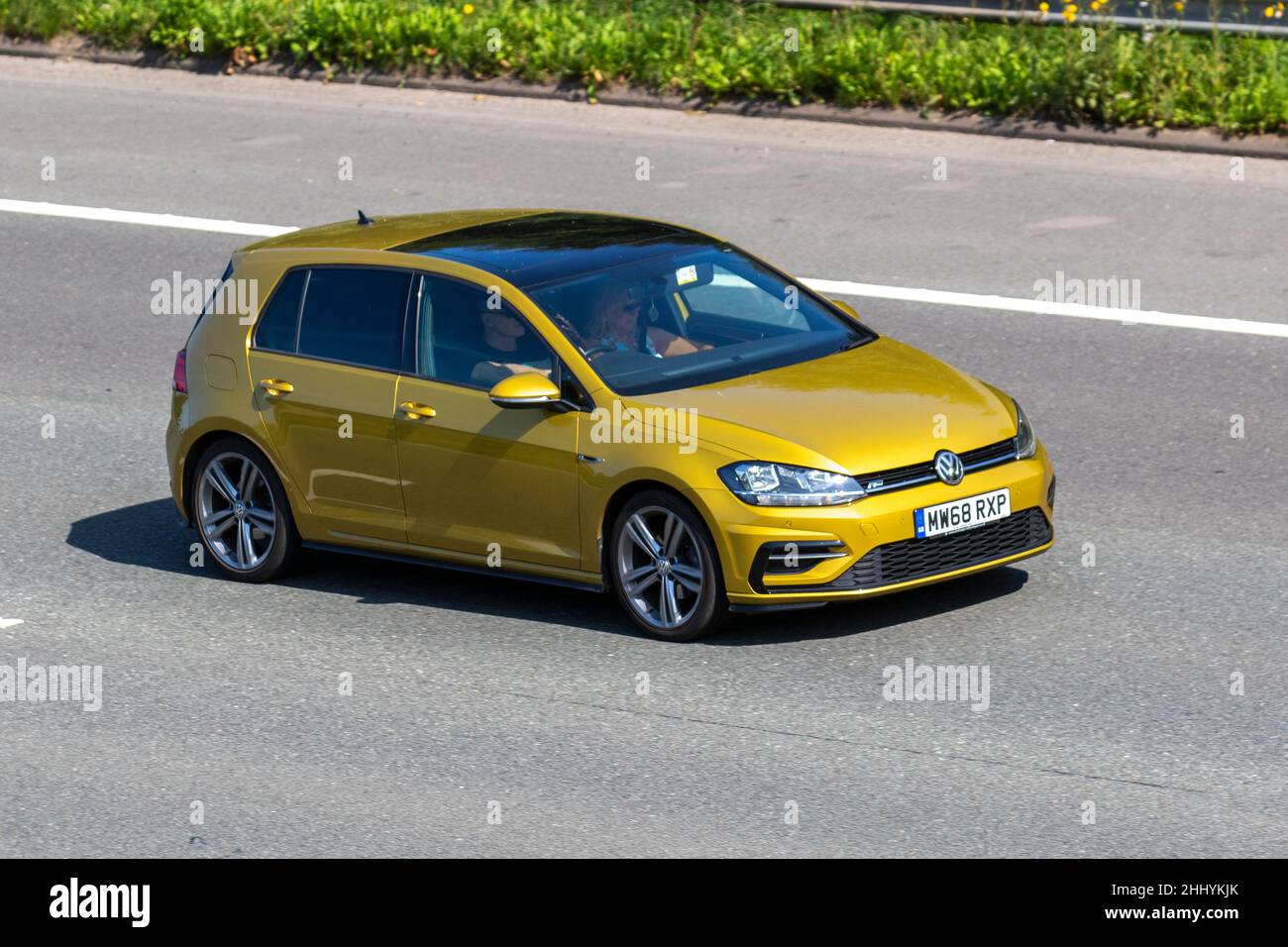 2019 Yellow Gold VW Volkswagen Golf 1498cc 4dr; Vehicular traffic, moving vehicles, cars, vehicle driving on UK roads, motors, motoring on the M6 motorway highway UK road network. Stock Photo