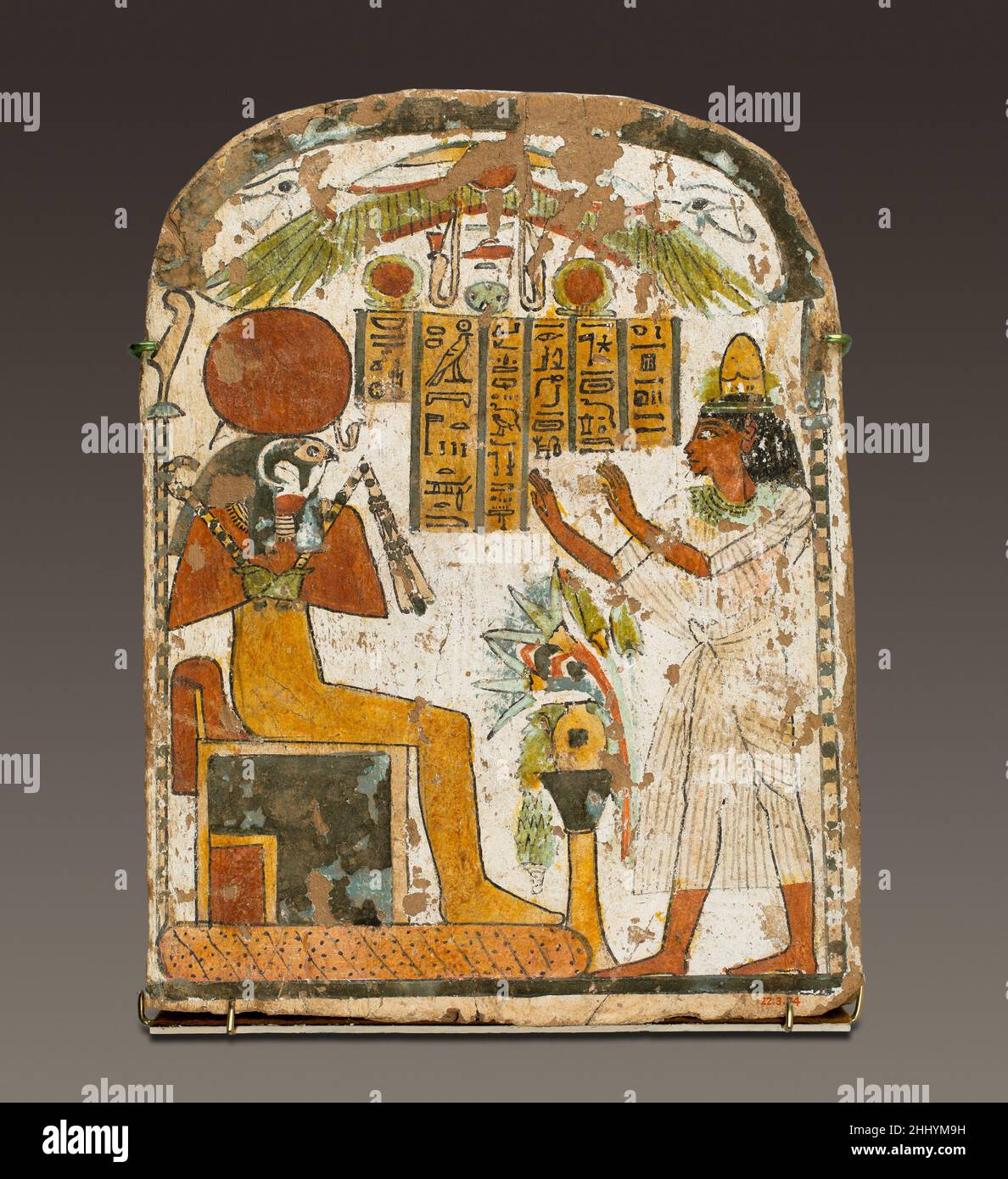 Painted stela of Djedbastet ca. 825–712 B.C. Third Intermediate Period This stela is one of four found near the doorway of a brick chapel built during the 22nd Dynasty (ca. 800 B.C.) in the courtyard of a usurped tomb of Dynasty 11 (ca. 2050 B.C.). The painted panels belong to family members and associates of a wab (purification) priest named Siah. All of the stelae are painted in green, red, yellow and black on a white ground.Here Djedbastet, son of Penby, raises his arms in adoration before the falcon-headed Re-Harakhty-Atum. The inscription identifies him as a wab priest of Amun and a Scrib Stock Photo