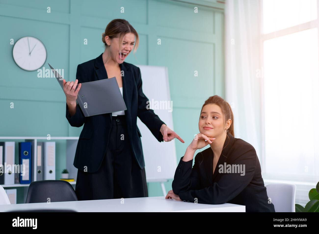 Boss screaming at frustrated employee, bullying and emotional abuse at work. Toxic work environment. Angry female irate boss yelling and shouting at h Stock Photo