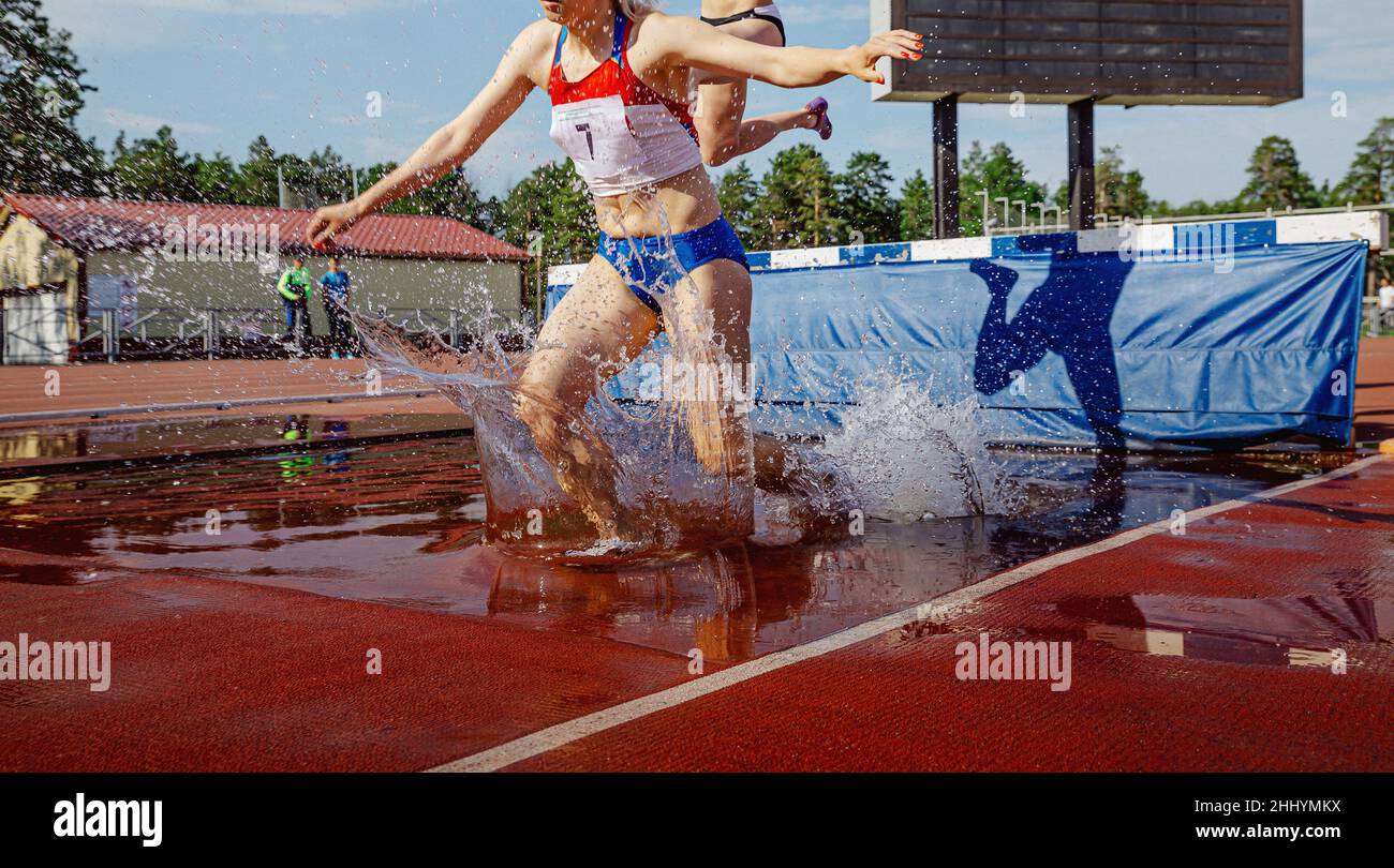 female athlete running steeplechase race in stadium athletics Stock Photo