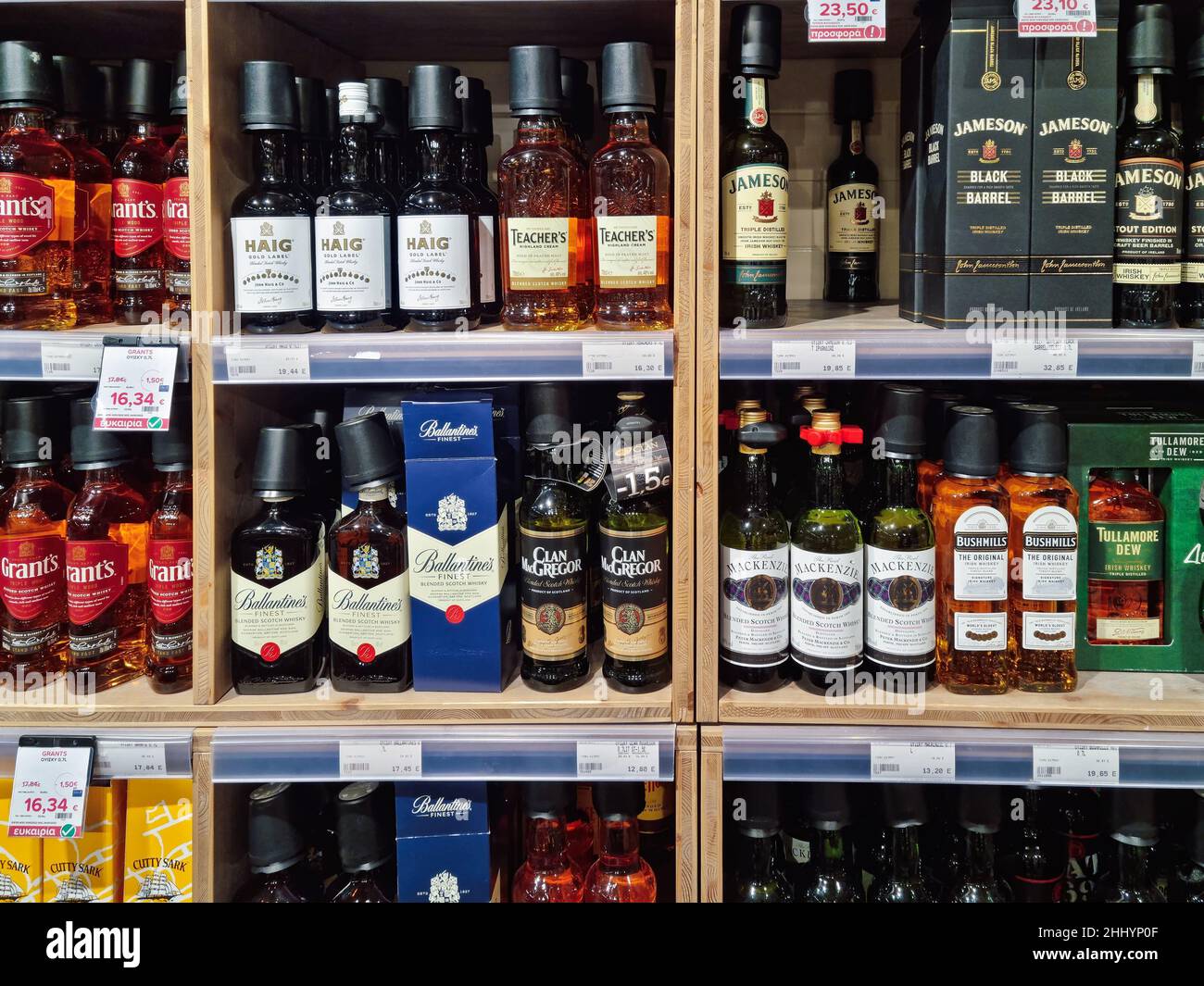 Liquor store display with various brands. Supermarket shop interior with glass bottles of whiskey alcoholic drinks on sale. Stock Photo