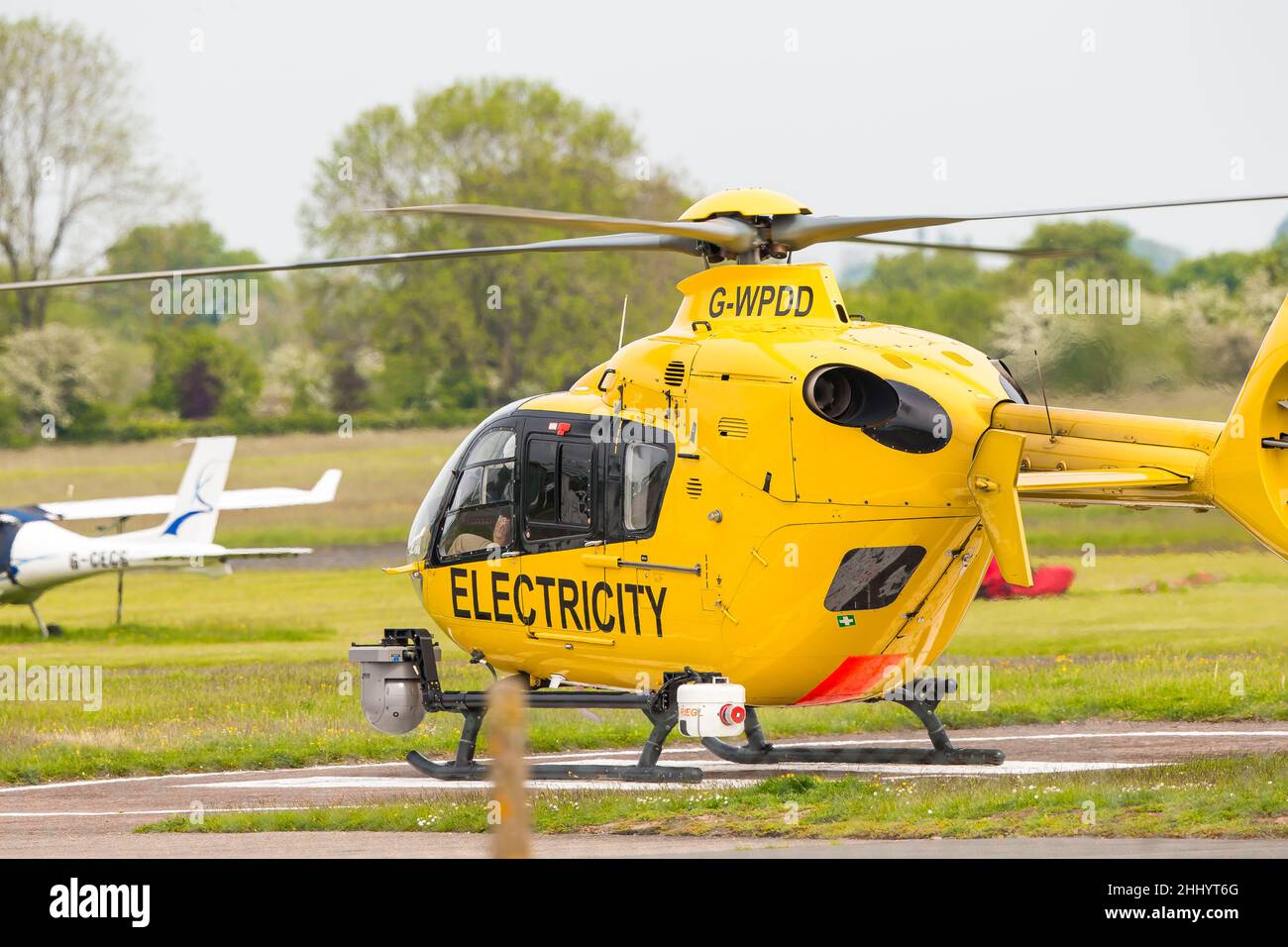 Yellow WPD helicopter (used in electricity distribution industry for network maintenance/repair/power line inspection) on ground ready for take off. Stock Photo