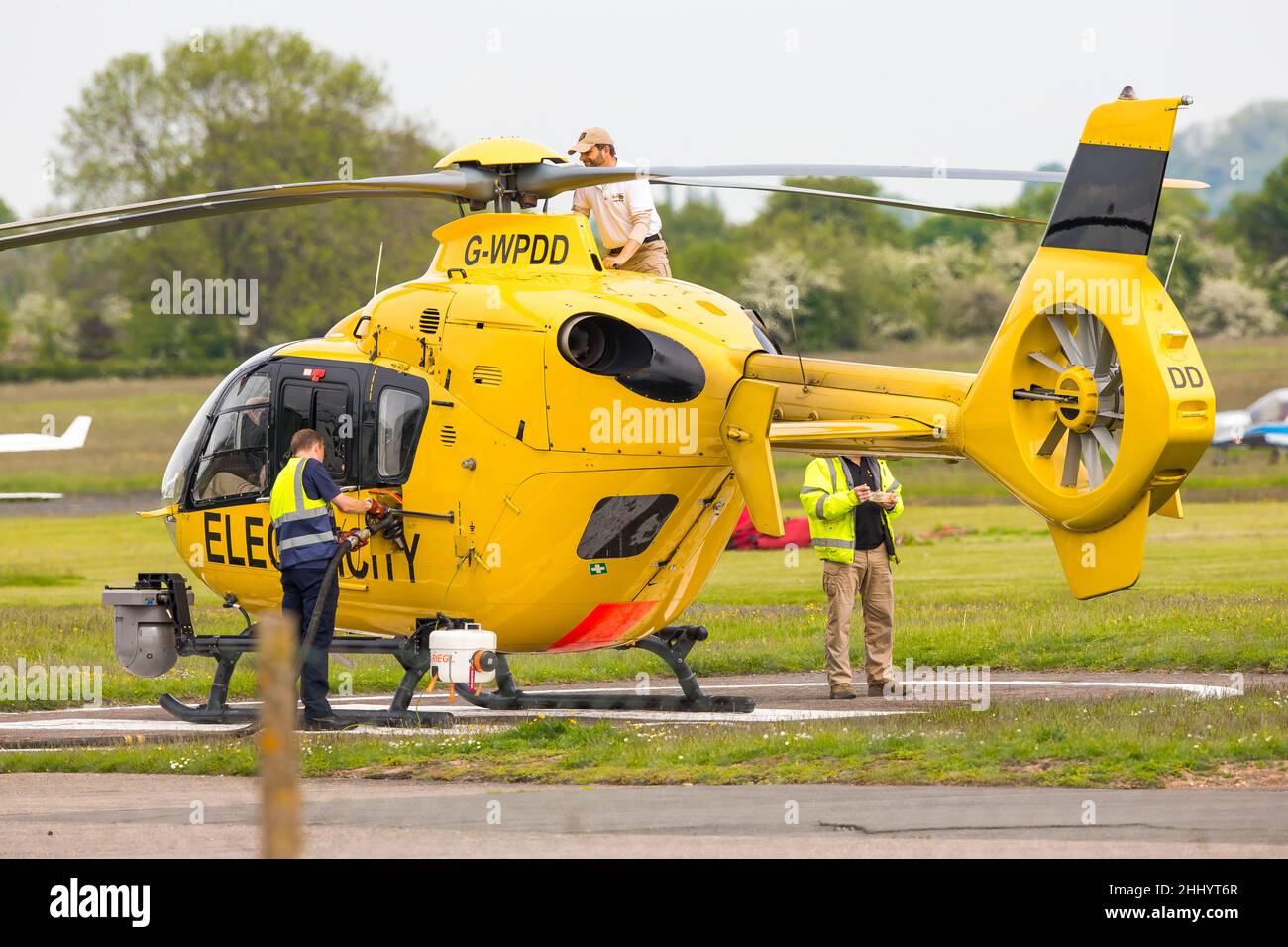 Yellow WPD helicopter used in electricity distribution industry for network maintenance/repair refuelling at Halfpenny Green Airport, Staffs, UK. Stock Photo