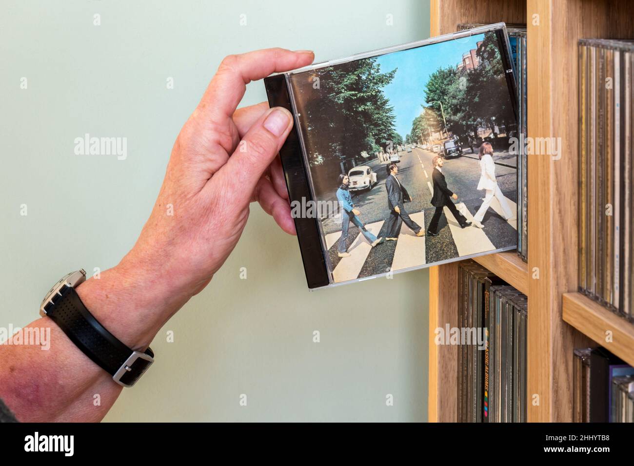 A CD of Abbey Road by The Beatles being removed from a rack. It was the 11th studio album by The Beatles, released in 1969. Stock Photo