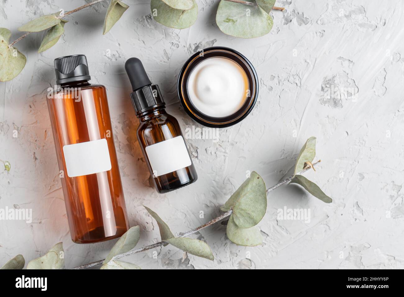 Cosmetic glass bottles with cream, toner and face mask on concrete  background with dry eucalyptus leaves. The concept of a beauty natural  cosmetics Stock Photo - Alamy