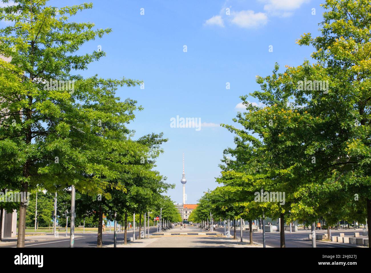 Tree-lined street and park in Berlin, Germany. Clear blue sky