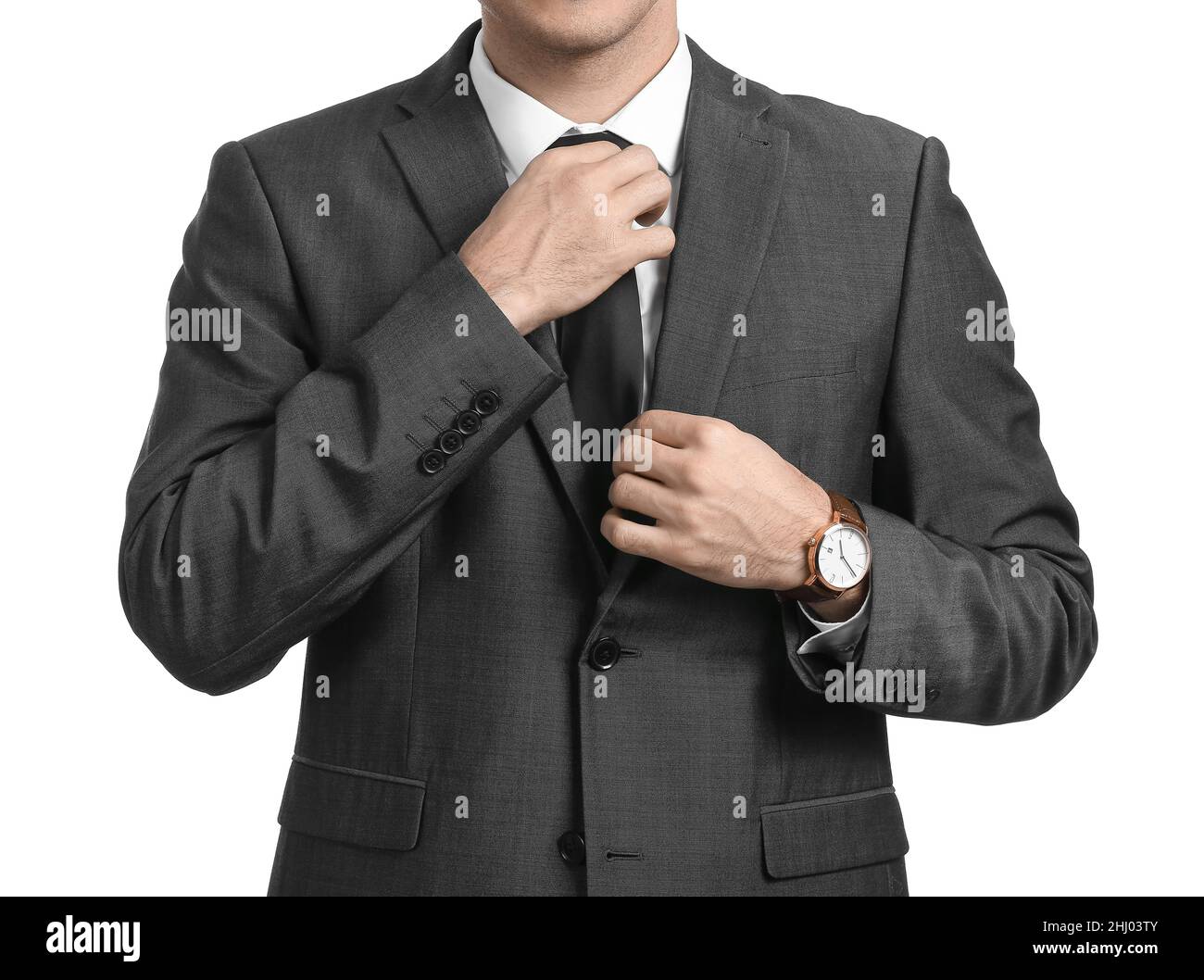Handsome man in formal suit adjusting tie on white background, closeup ...