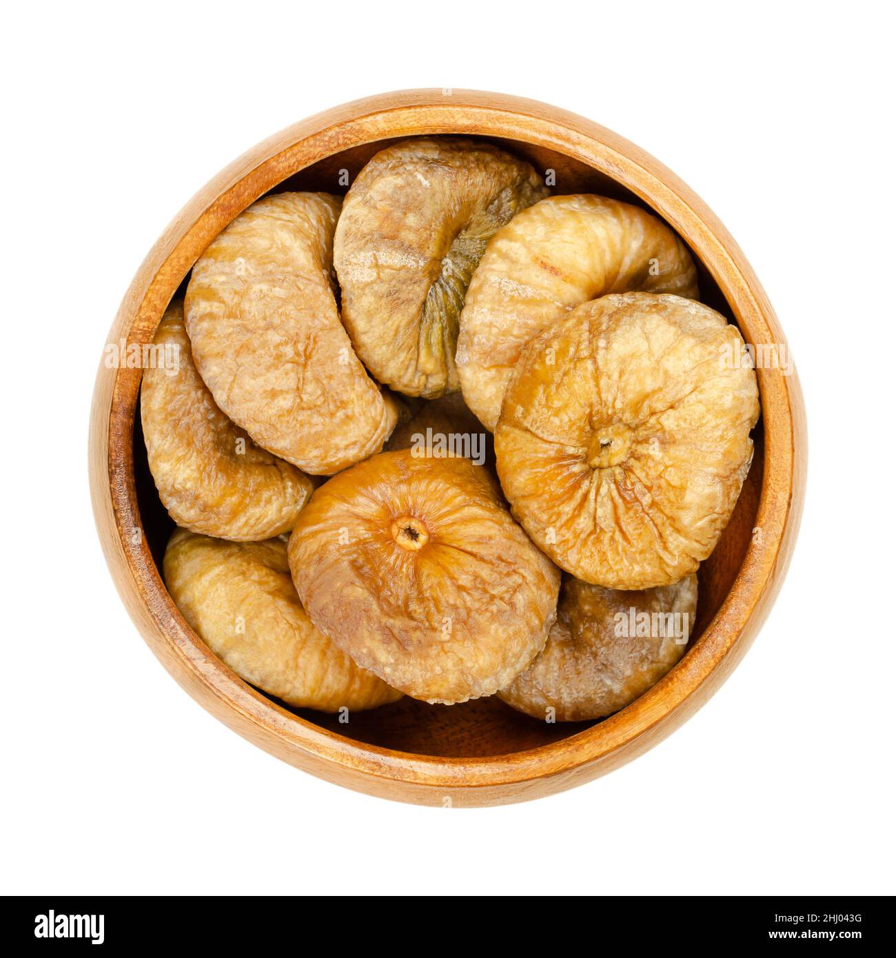 Dried figs in a wooden bowl. Sun dried, ripe and whole common figs, edible and uncooked fruits of Ficus carica, a popular snack in the wintertime. Stock Photo