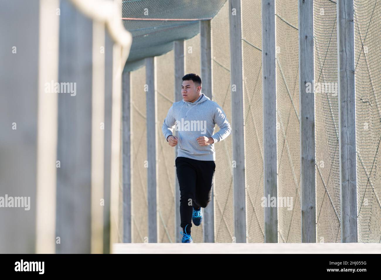Lating athlete running through a promenade Stock Photo