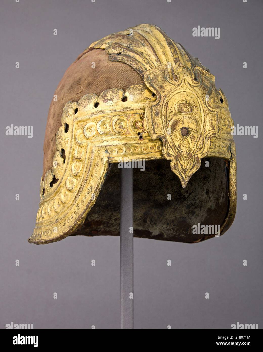 Sallet alla Veneziana ca. 1470; gilt mounts, probably added early 16th century Italian Italian paintings of the fifteenth century provide ample evidence that color played an important role in the appearance of the armored knight. The metal plates themselves were often colored by heat to a blue or black finish, and the edges were sometimes enriched with gilt metal borders; rich brocades and velvets frequently covered the armor, and huge crests composed of gilt metal, leather, parchment, and feathers surmounted the helmet. Helmets decorated in this way appear to have had great popularity in veni Stock Photo