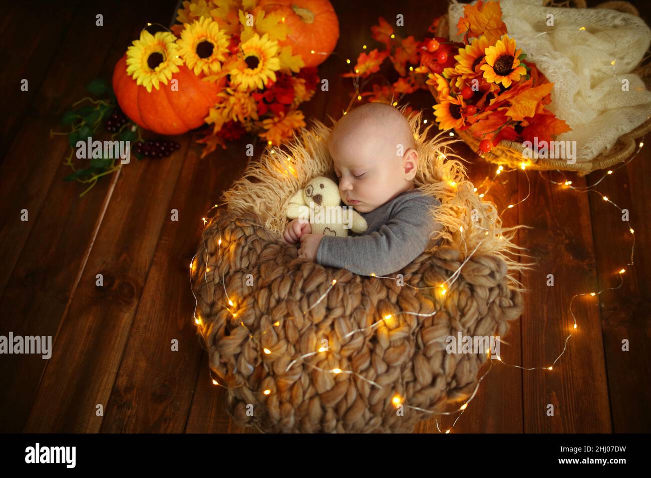baby sleeps in a basket hugging a soft toy Stock Photo Alamy