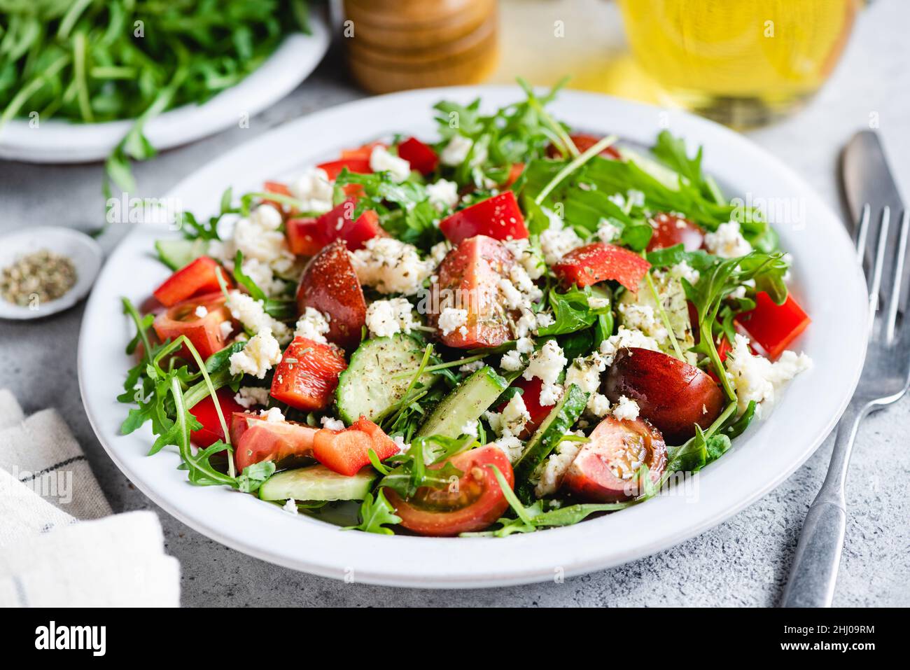 Vegetable salad with goat cheese, arugula salad leaf and cherry tomatoes on a flat plate Stock Photo