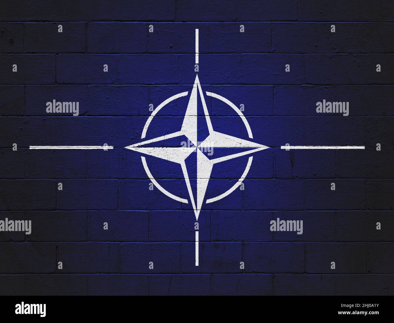Flag of the NATO military alliance painted on a brick wall Stock Photo
