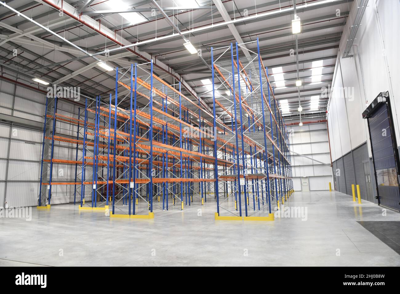 Empty shelves in a new warehouse. Racks in a distribution stockhouse. Concept suggesting supply shortages, logisitcal problems or stock issues. Stock Photo