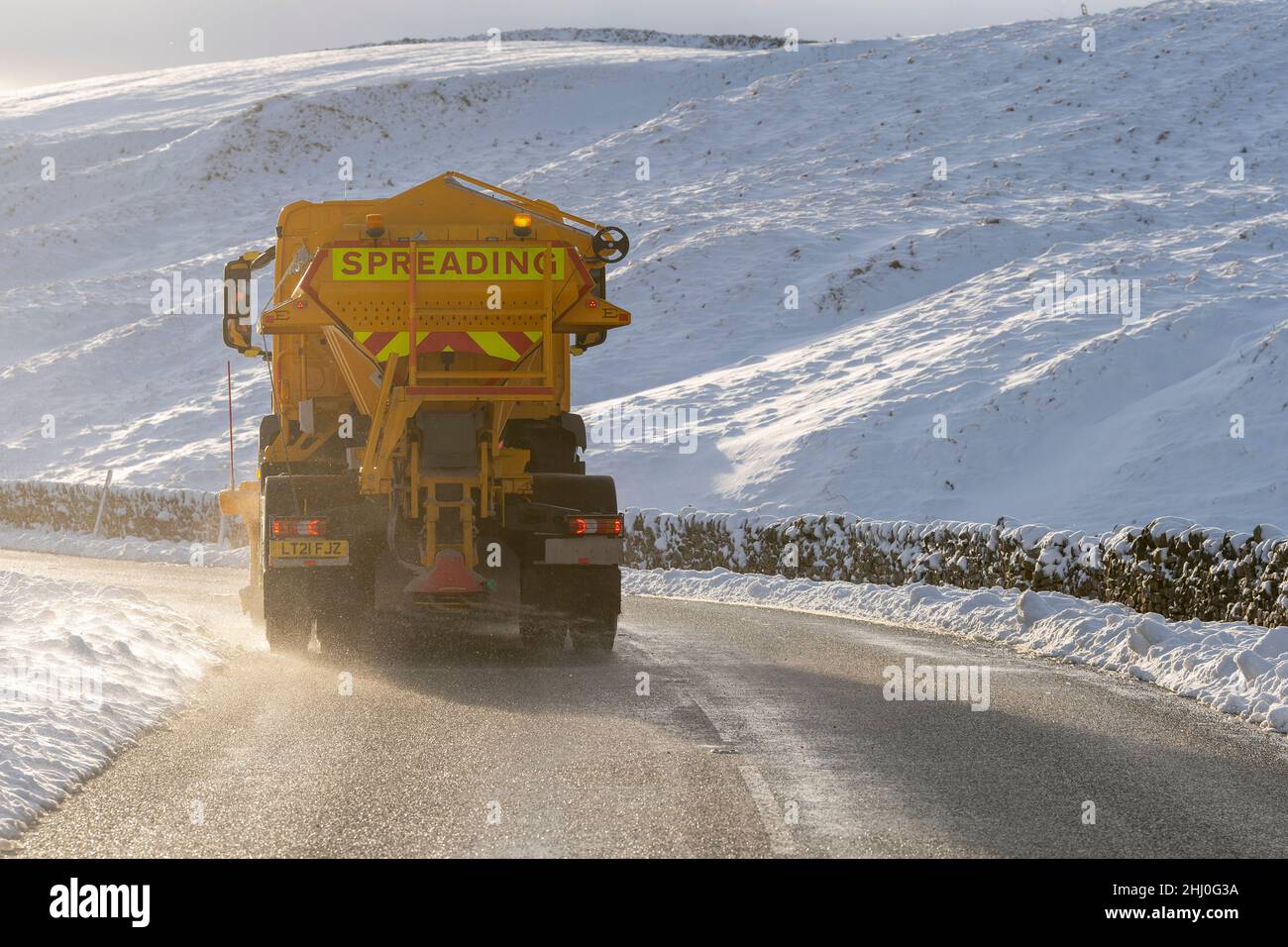 Council wagons gritting a rural road with salt after a snow storm, North Yorkshire, UK. Stock Photo