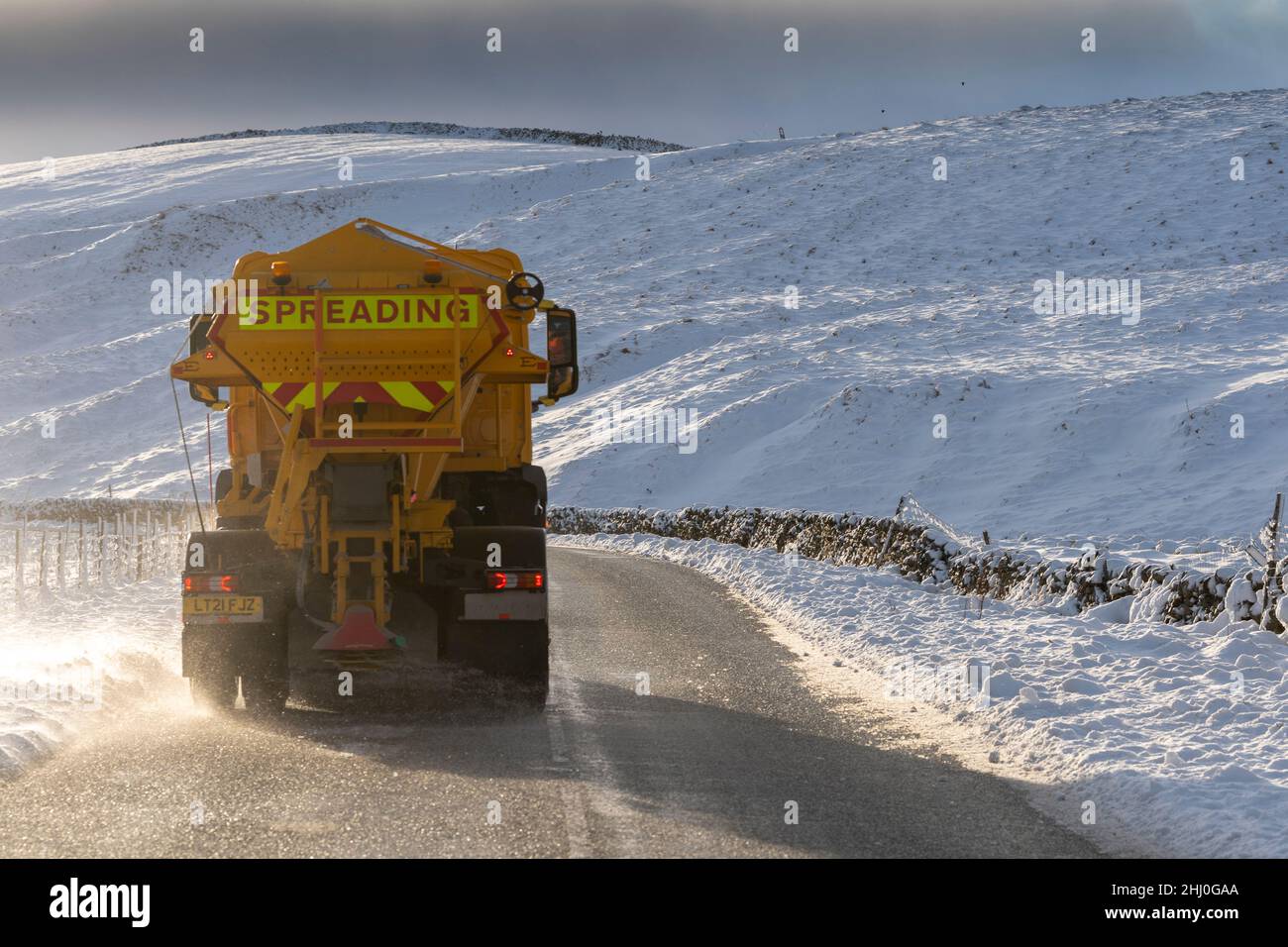 Council wagons gritting a rural road with salt after a snow storm, North Yorkshire, UK. Stock Photo