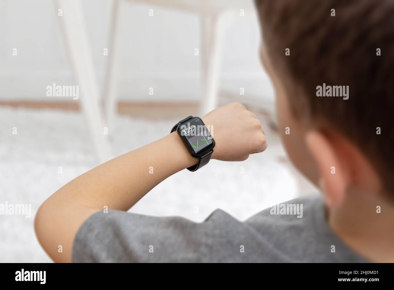Boy monitoring diabetes from watch concept. App displays the level of glucose in the blood read from a sensor on hand Stock Photo