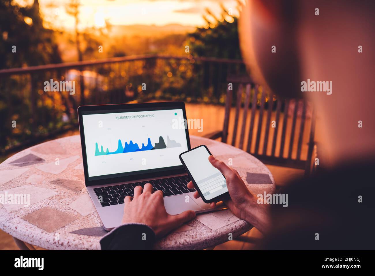 Anonymous man typing on laptop on terrace Stock Photo