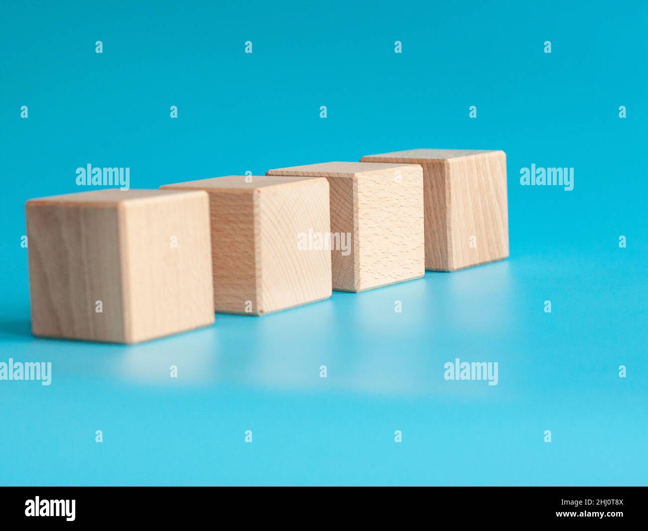 Wooden cube on blue background with space for text Stock Photo - Alamy