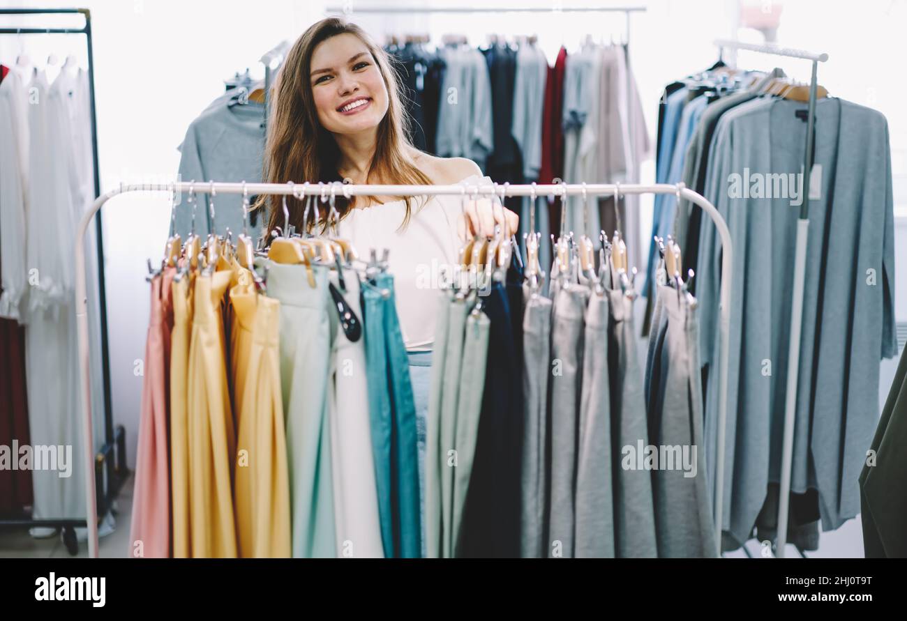 Cheerful woman choosing garments in shop Stock Photo