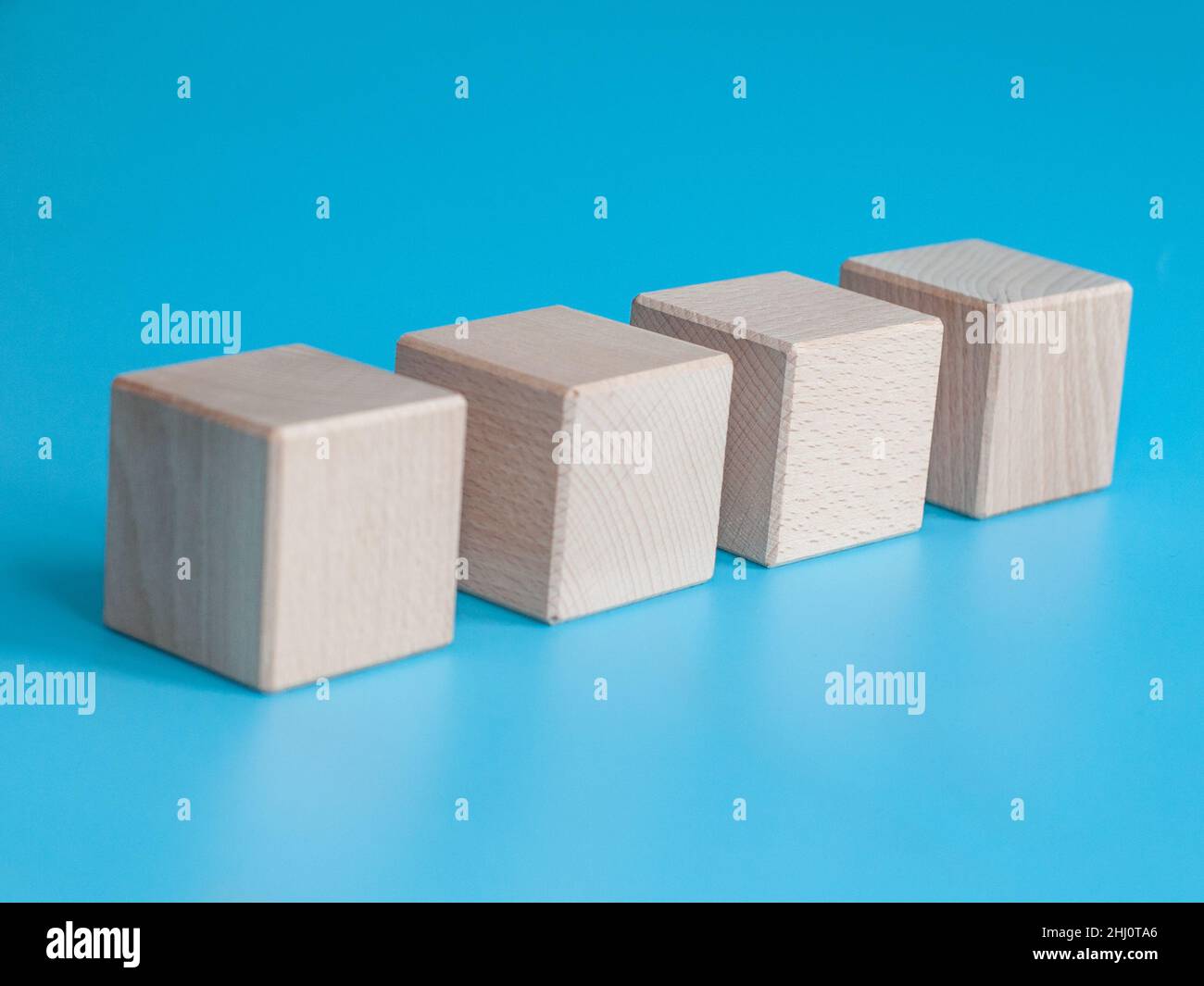 Wooden cube on blue background with space for text Stock Photo - Alamy