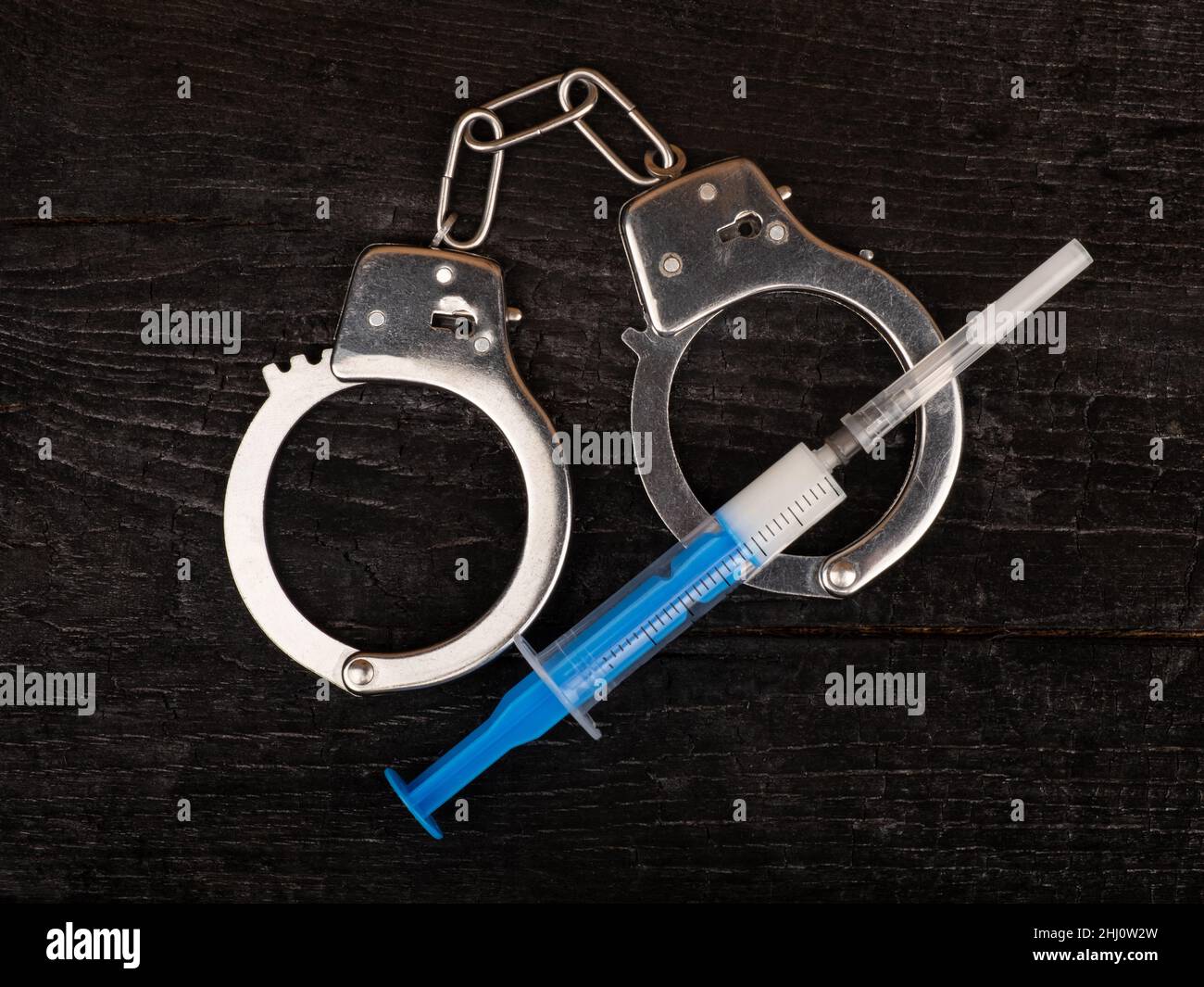 drug syringe and handcuffs,arrest drug dealer..... Stock Photo