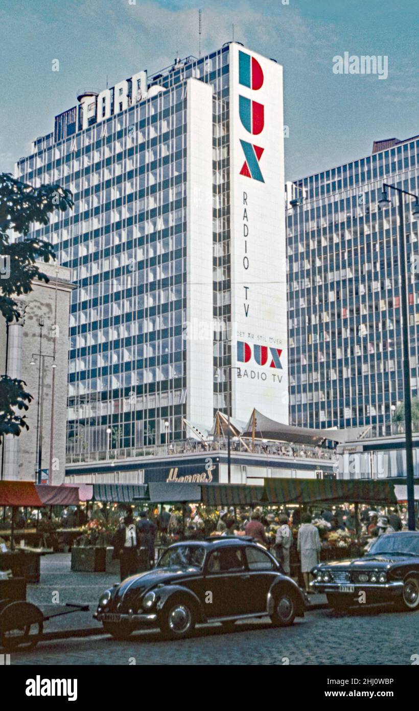 A view of the Hötorget buildings (Hötorgshusen or Hötorgsskraporna) in the central Norrmalm district, Stockholm, Sweden c.1960. In the foreground is the Hötorget torghandel (market) outside the Konserthuset (Consert House). The Hötorget buildings are five modernist high-rise office blocks. The nearest block carries a giant advertising logo for Dux TVs and radios. It also has the Ford logo at the top. This image is from an amateur 35mm colour transparency – a vintage 1950s/1960s photograph. Stock Photo